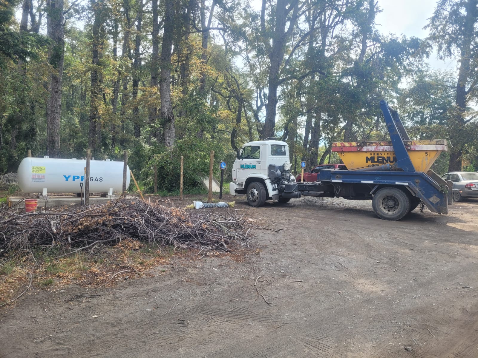 Camión de Milenium retirando un volquete junto a una obra