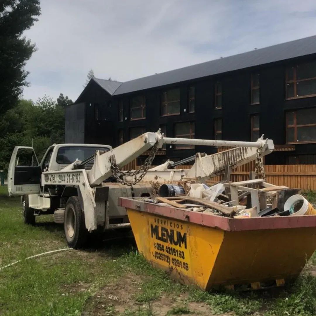 Camión de Milenium retirando un volquete con restos de demolición