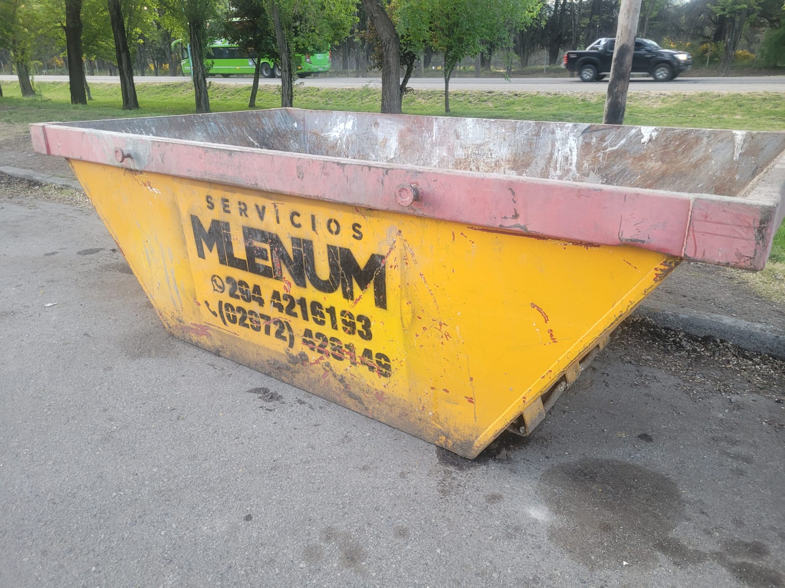 Volquete amarillo de Servicios Milenium con la marca y los teléfonos de contacto